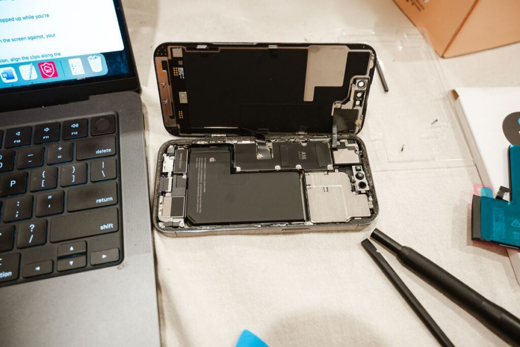 Laptop and phone with repair tools for a back-to-school tune-up