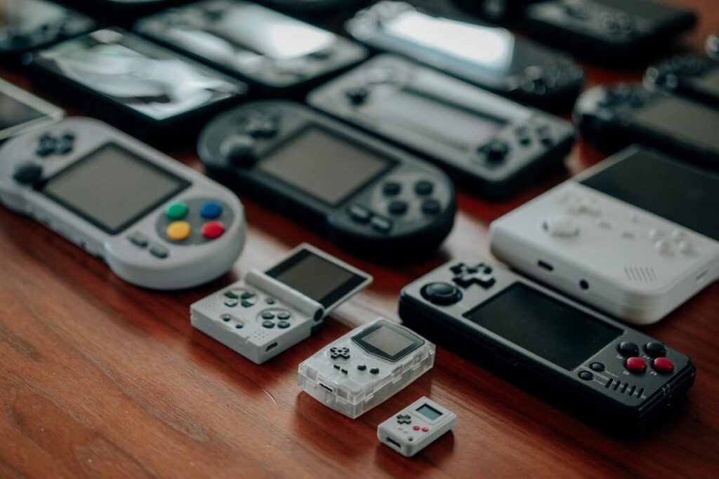 Collection of retro handheld game consoles on a wooden table
